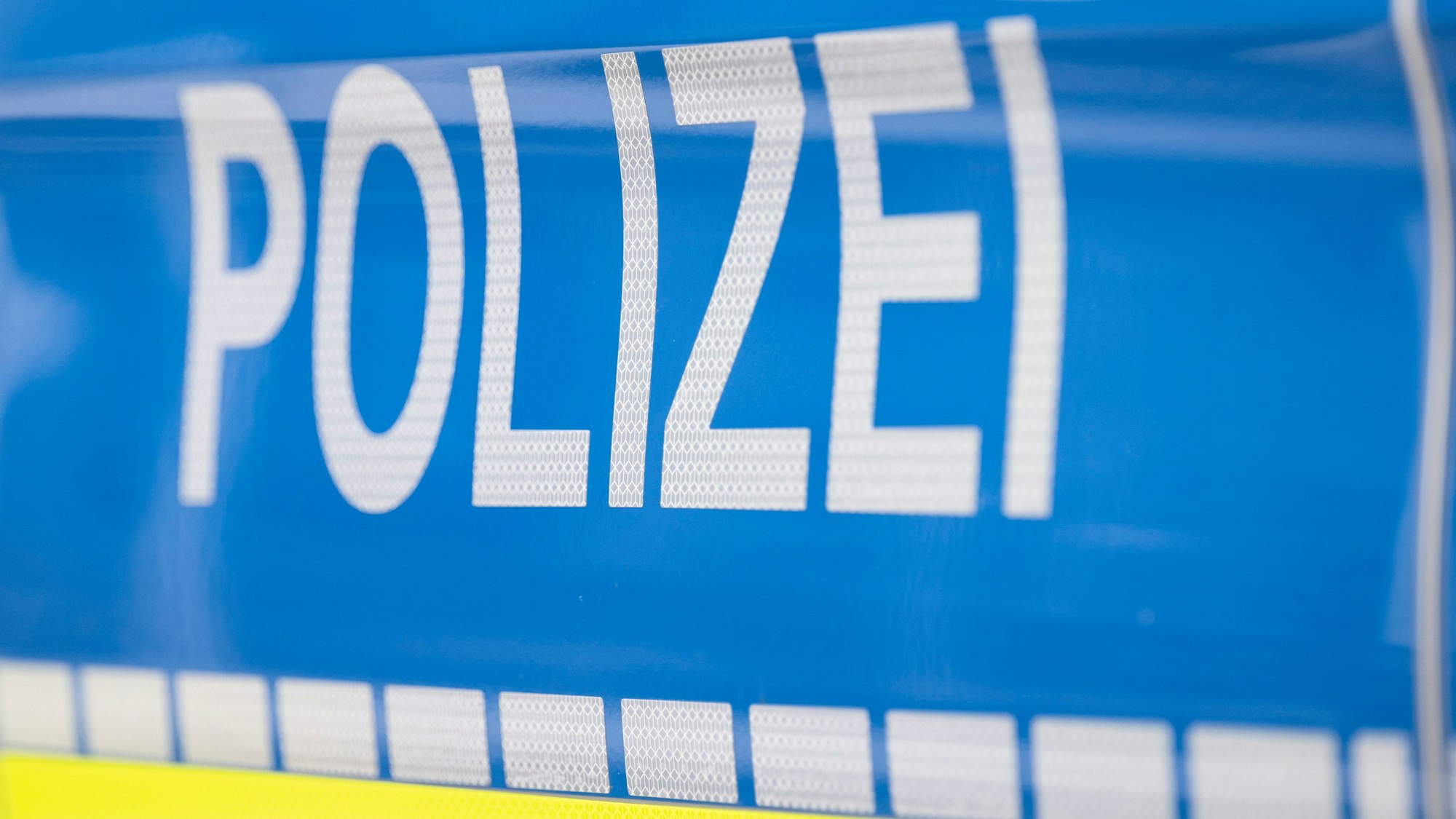 Der Schriftzug „Polizei“ ist auf einem Streifenwagen zu lesen.