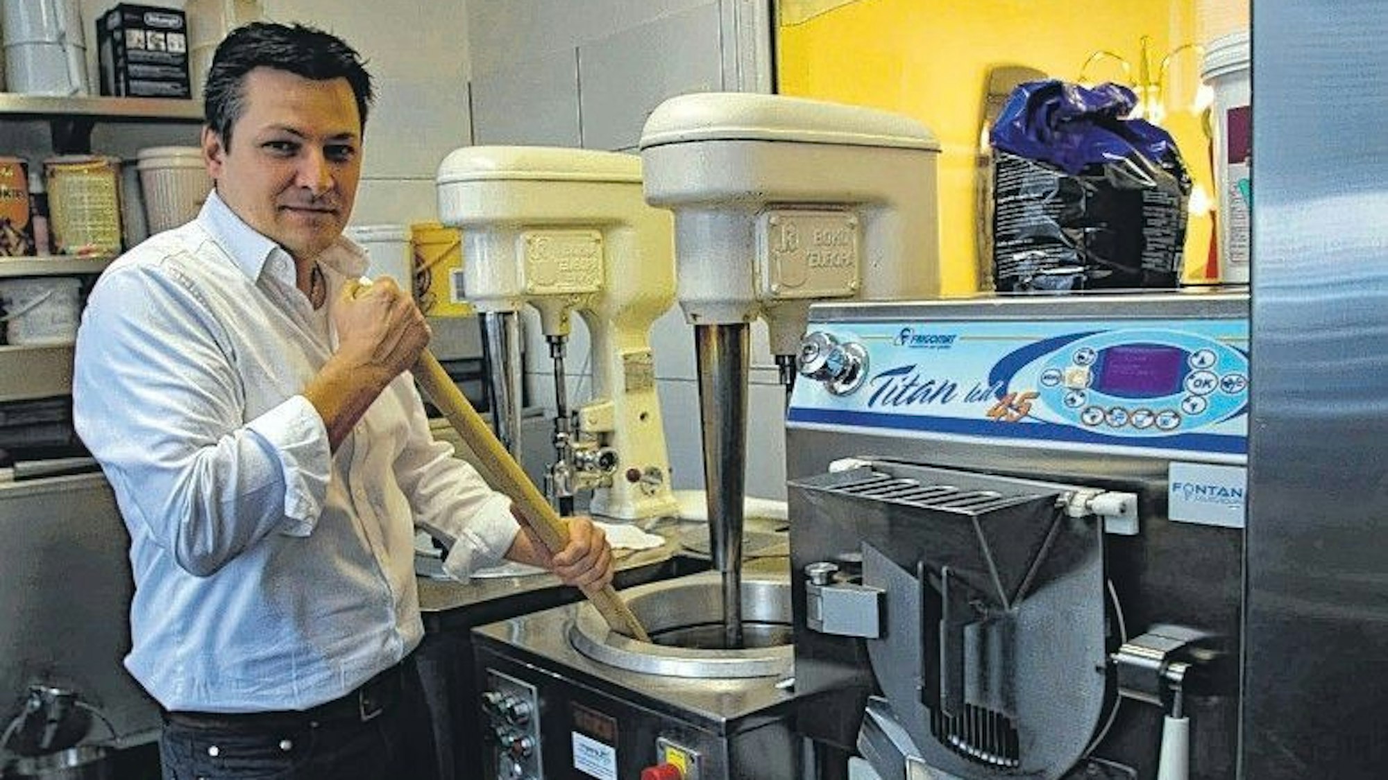 Antonoi Campo-Bagatin in seiner Filiale in Kerpen-Horrem an der Eismaschine, im Hintergrund alte Modelle, die früher auch am Tresen standen.