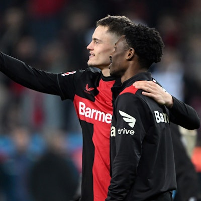 Leverkusens Florian Wirtz (l) und Nathan Tella machen ein Bild mit einem Handy.