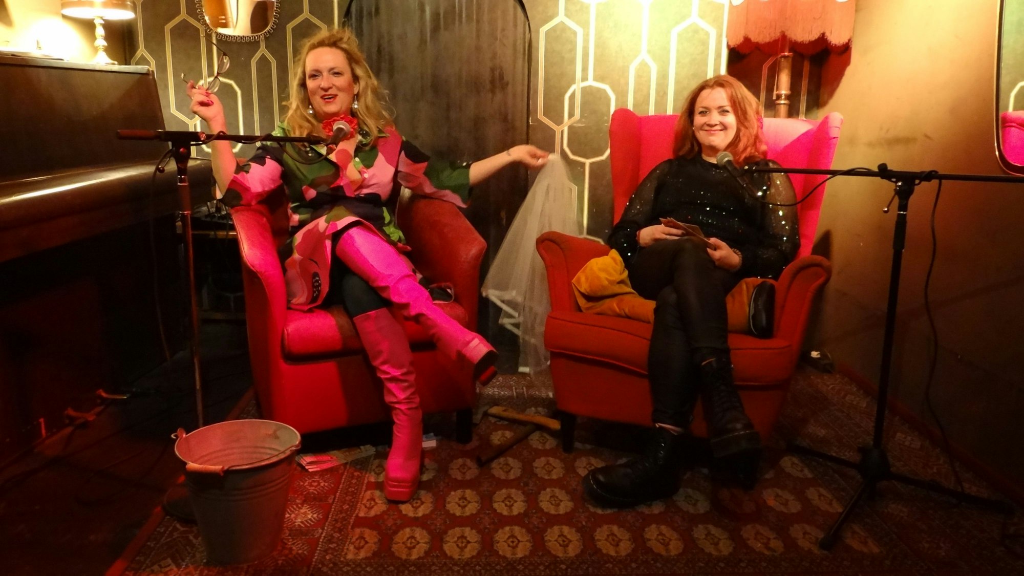 Zwei Frauen sitzen in Sesseln nebeneinander.