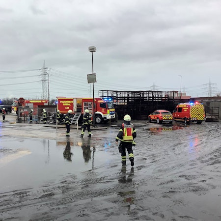 Einsatzkräfte der Feuerwehr Brühl stehen auf dem Gelände des Brühler Eisenwerks.