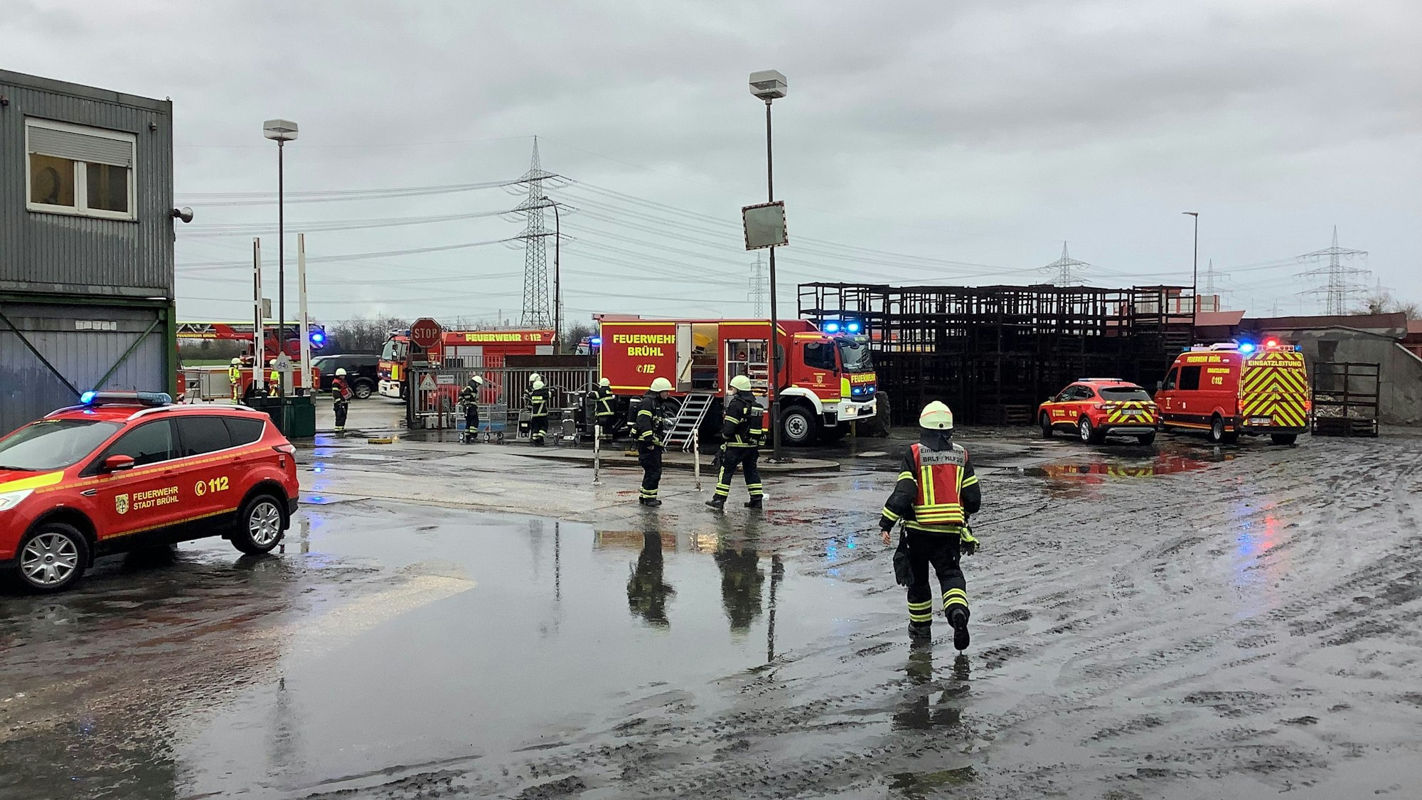 Einsatzkräfte der Feuerwehr Brühl stehen auf dem Gelände des Brühler Eisenwerks.