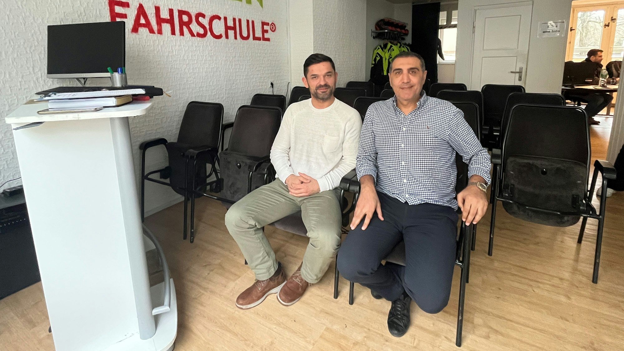 Ivan Milardovic (l.), Inhaber der Fahrschule Green und sein Mitarbeiter Hüseyin Yavuz sitzen im Theorieraum der Fahrschule.
