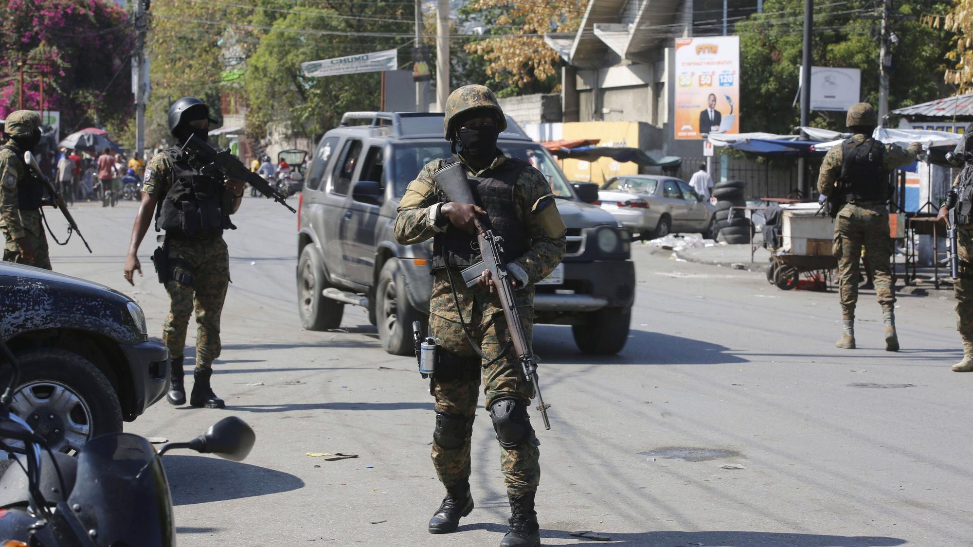 09.03.2024, Haiti, Port-au-Prince: Mitglieder der Allgemeinen Sicherheitseinheit des Nationalen Palastes (USGPN) errichten eine Sicherheitsabsperrung um einen der drei Bahnhöfe im Stadtzentrum, nachdem die Polizei am Vortag einen Angriff von Banden abgewehrt hat.