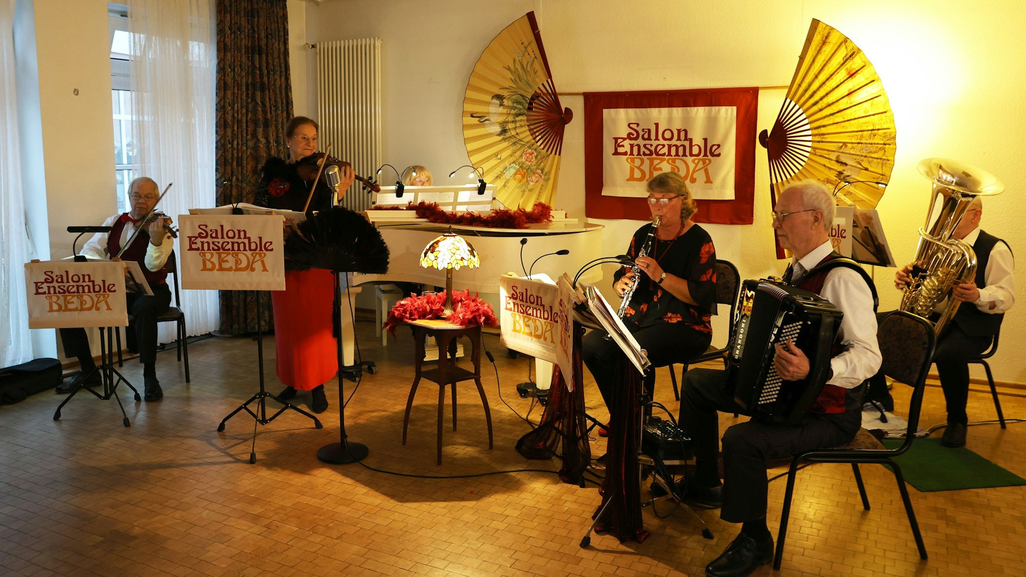 Die Mitglieder des Ensembles spielen im stimmungsvoll beleuchten Gemeindesaal.