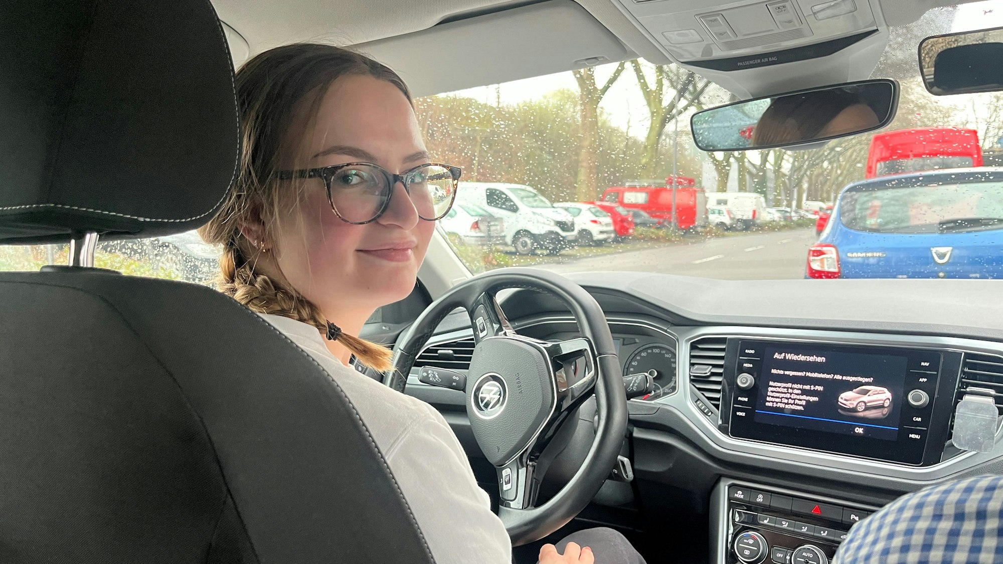 Mia Walther sitzt in einem Auto und guckt schräg über ihre Schulter in die Kamera.