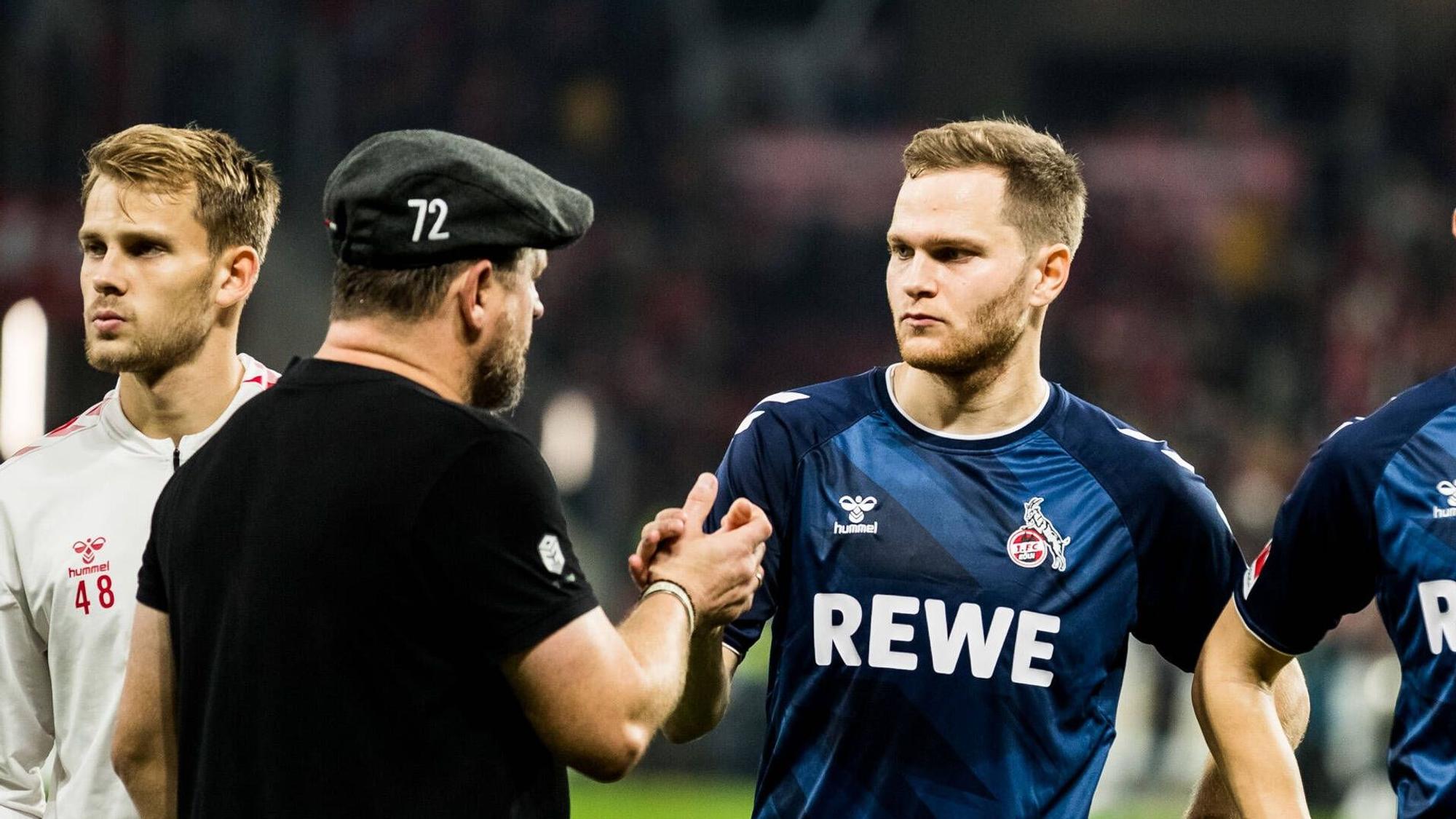 Benno Schmitz und Trainer Steffen Baumgart vom 1. FC Köln klatschen sich nach dem Schlusspfiff ab.