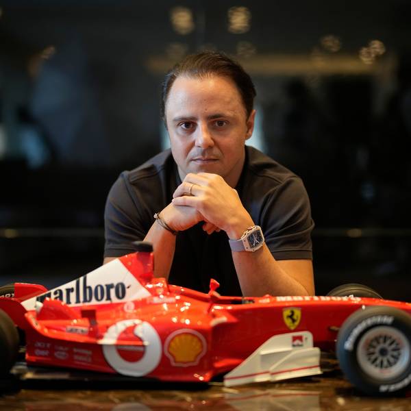 Felipe Massa sitzt vor einem kleinen Modell-Ferrari.