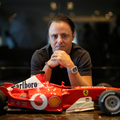 Felipe Massa sitzt vor einem kleinen Modell-Ferrari.