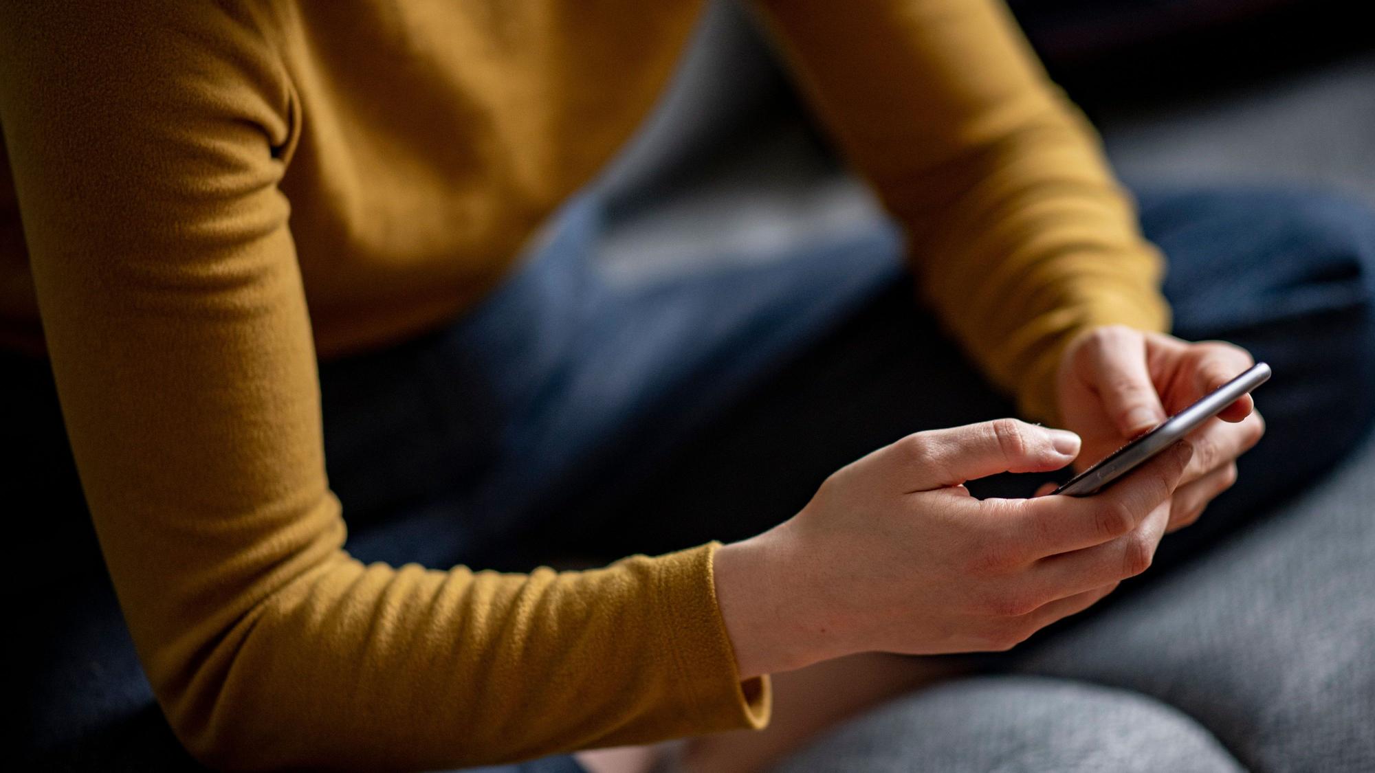 Eine Frau liest Nachrichten auf dem Smartphone
