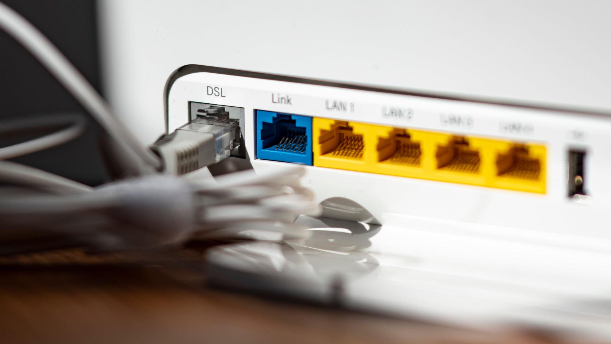 Ein LAN-Kabel steckt im DSL-Steckplatz eines WLAN-Routers.