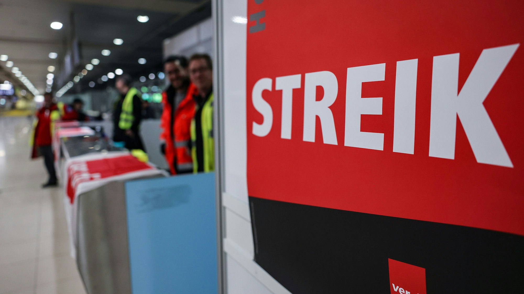 Ein Streikposten steht am Flughafen Köln/Bonn im Terminal. (Archivbild)