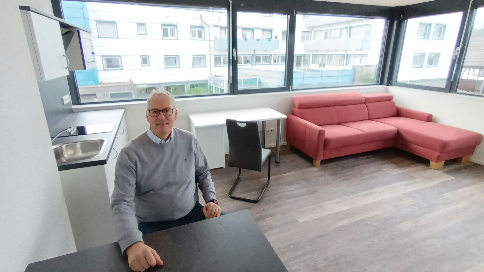 Ein Mann sitzt an einem Tisch in einem Appartement