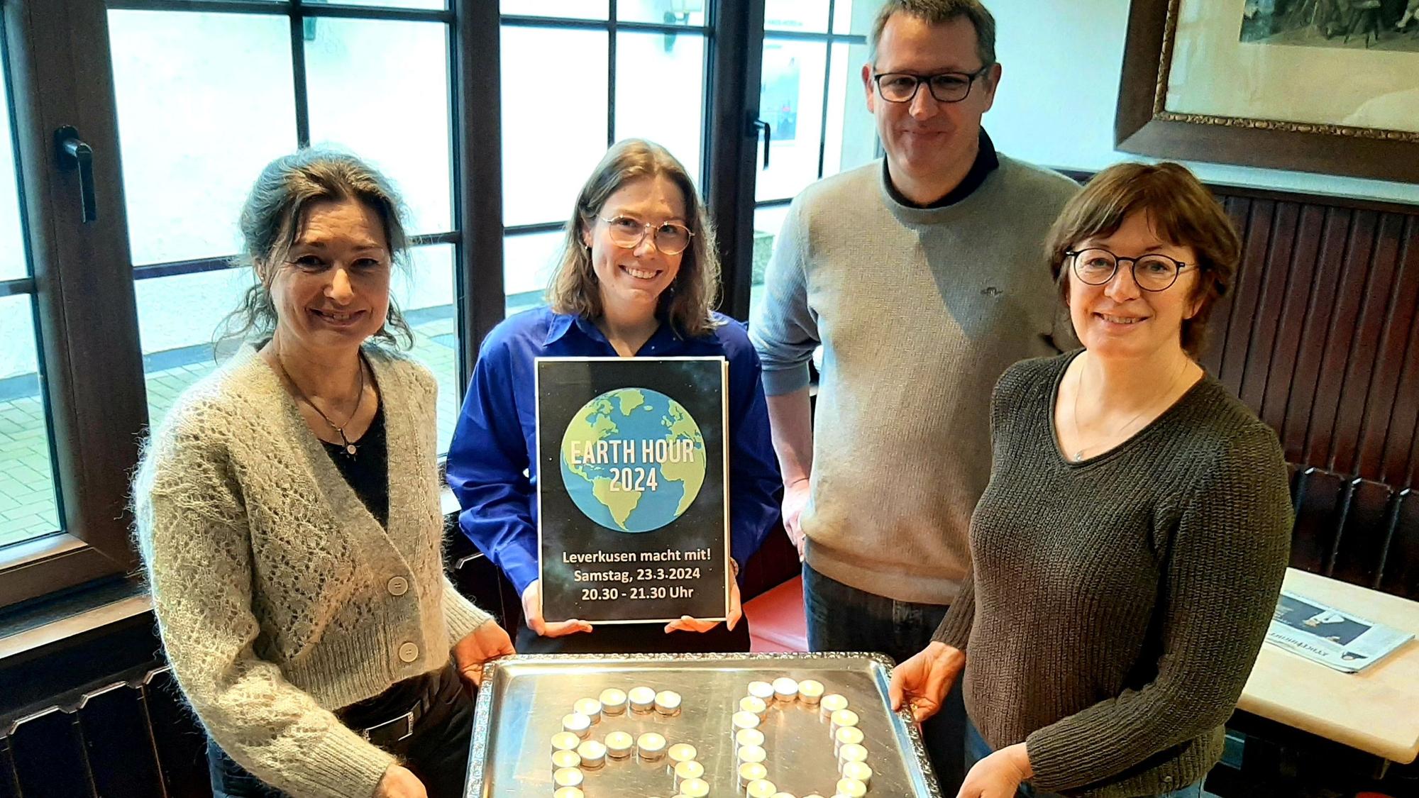 Sie nehmen am 23. März 2024 an der Earth Hour teil, bei der an und in städtischen Gebäuden sowie in beteiligten Gastronomiebetrieben 60 Minuten lang das Licht ausgeschaltet wrden (v.l.): Dagmar Hilge-Biegmann von der VHS Leverkusen, Steffi Bergmann von der Stadt, Gastronom Hagen Norhausen und Britta Demmer vom Naturgut Ophoven in Opladen.
