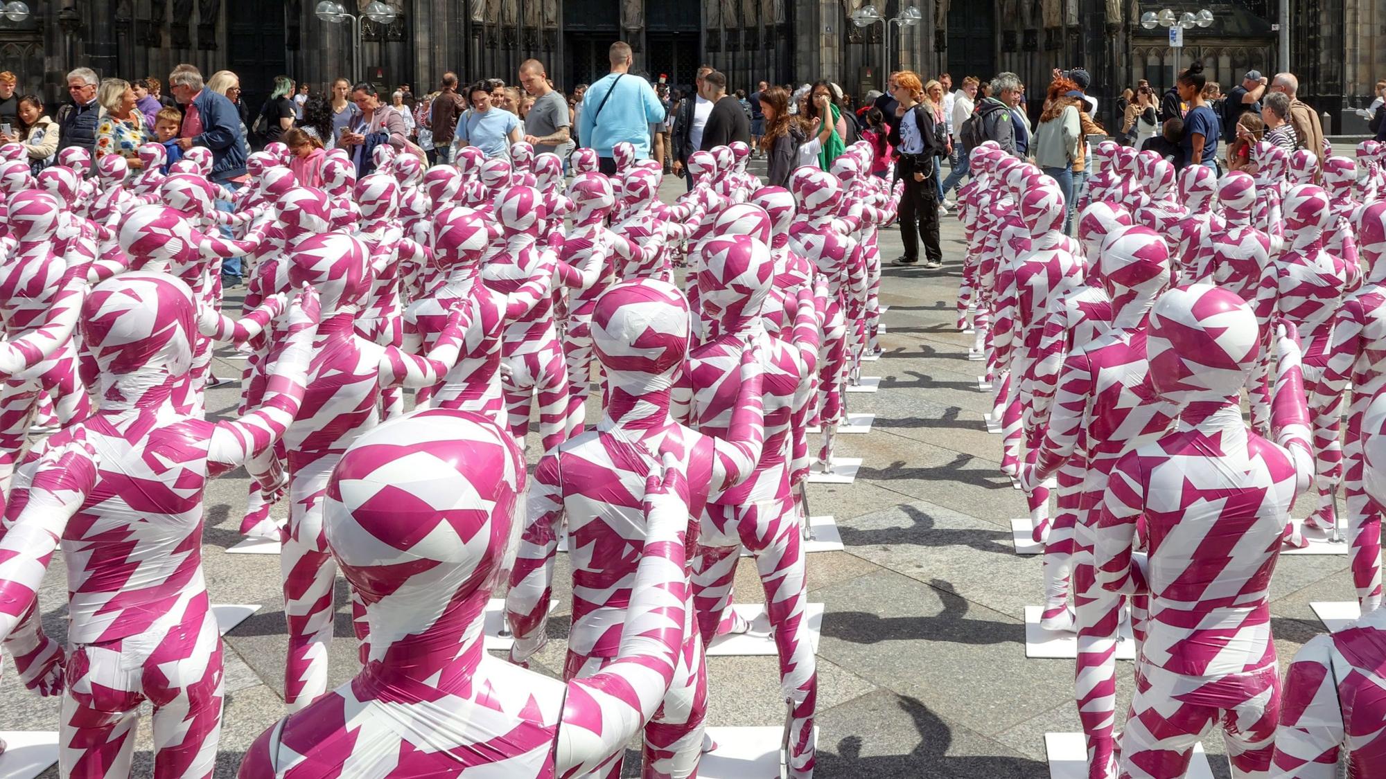 Eine Installation mit Kinderfiguren, die mit Flatterband umwickelt sind, vor dem Kölner Dom erinnert an den Missbrauchsskandal in der katholischen Kirche. (Archivbild)