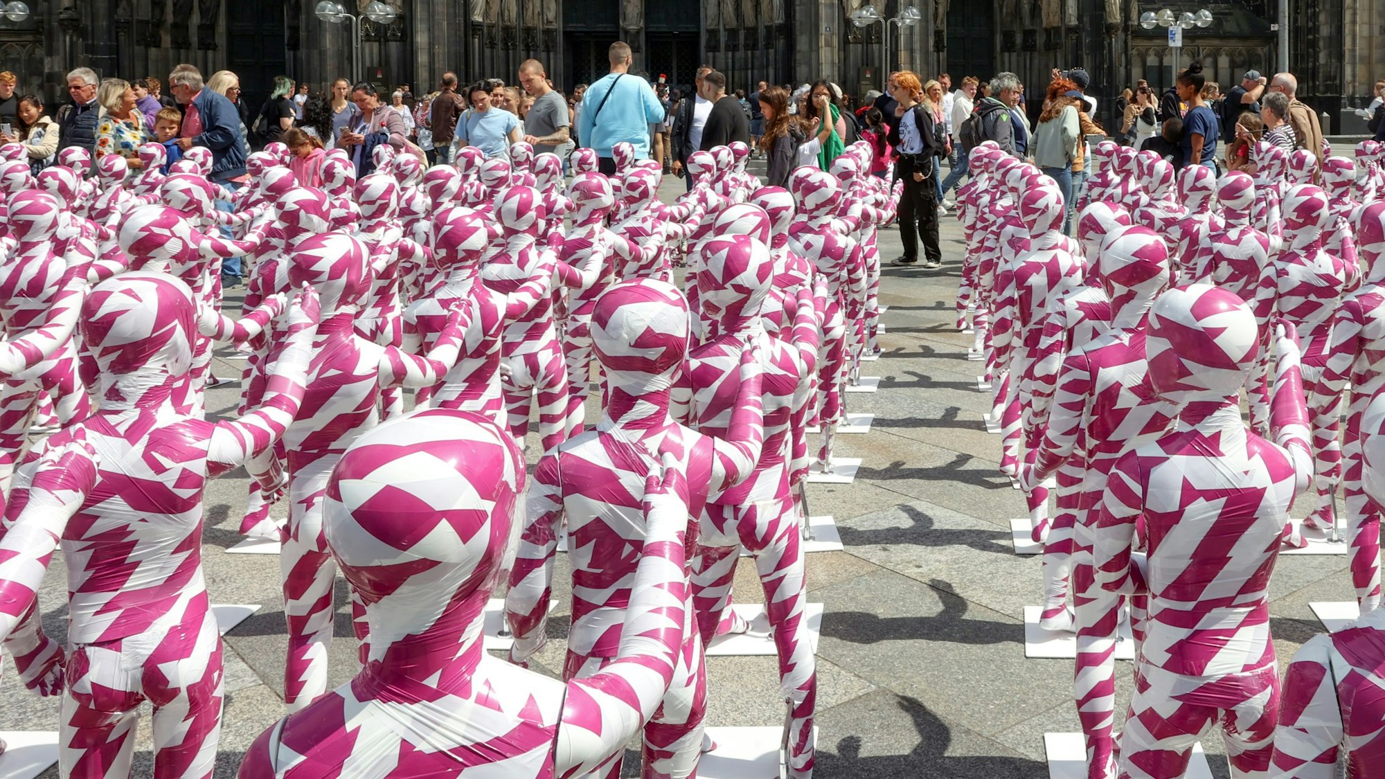 Eine Installation mit Kinderfiguren, die mit Flatterband umwickelt sind, vor dem Kölner Dom erinnert an den Missbrauchsskandal in der katholischen Kirche. (Archivbild)