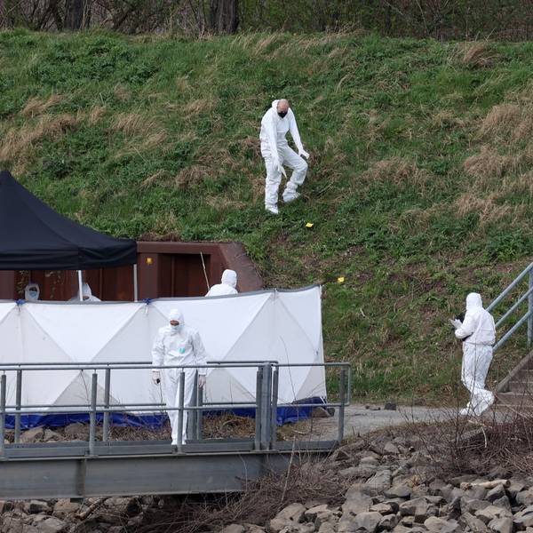 Spurensicherer der Polizei untersuchen eine Böschung am Tatort im Mülheimer Hafen.