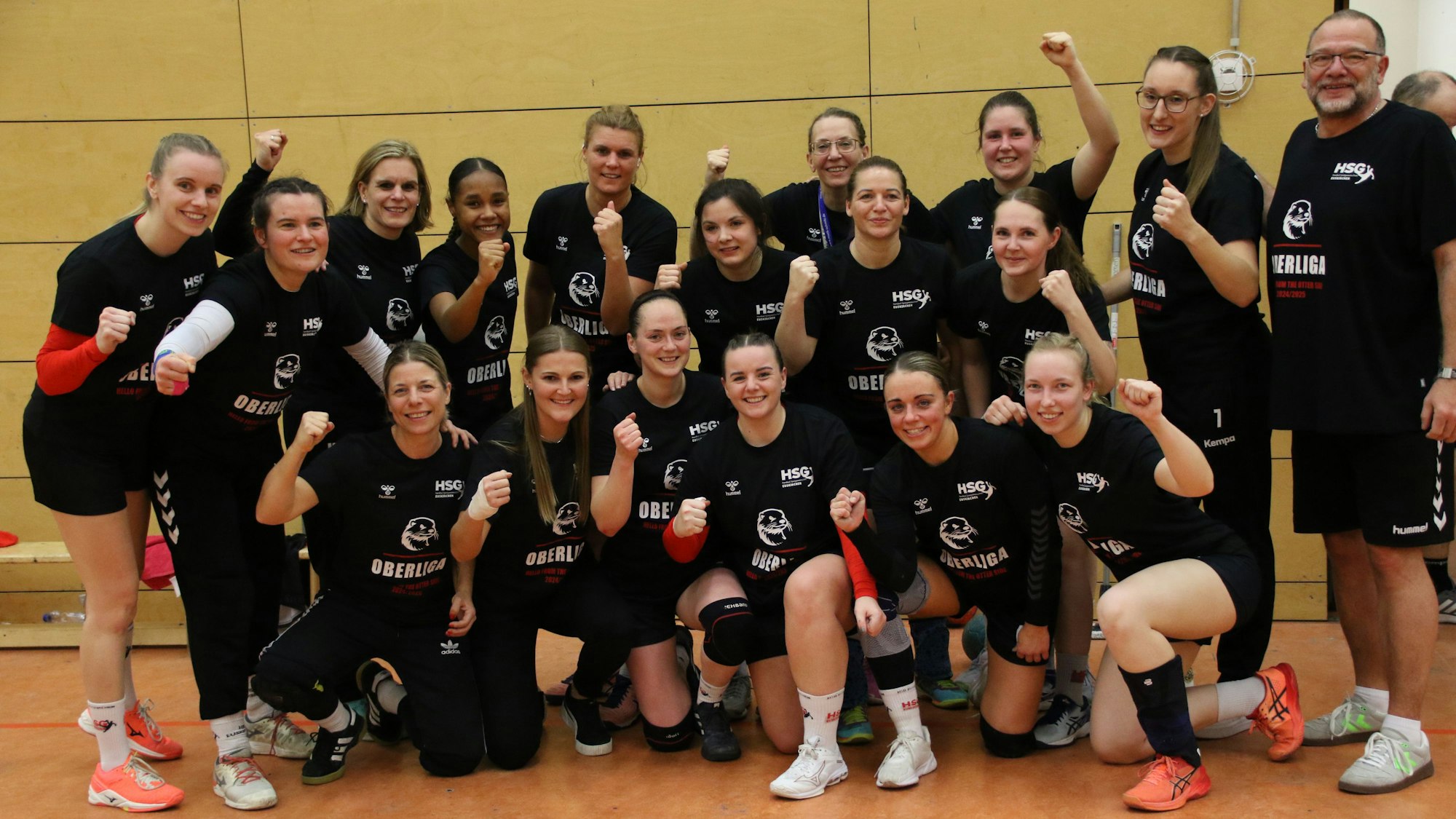 Die Frauen der HSG Euskirchen haben ihre Aufstiegstrikots an und jubeln mit erhobener Faust.