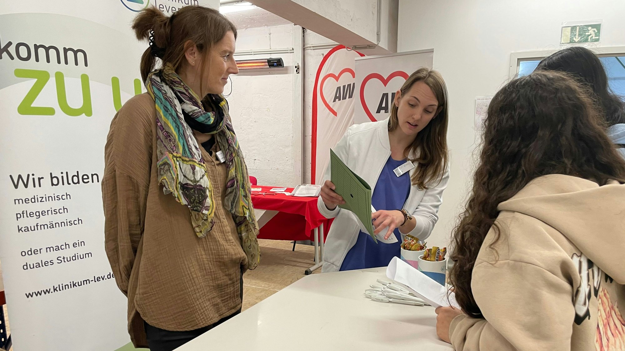 Lisa Neuß (r.) erklärt jungen Frauen, was sie bei einer Ausbildung im Klinikum Leverkusen erwartet. Eva Fischer (l.) arbeitet in der Personalabteilung des Krankenhauses.