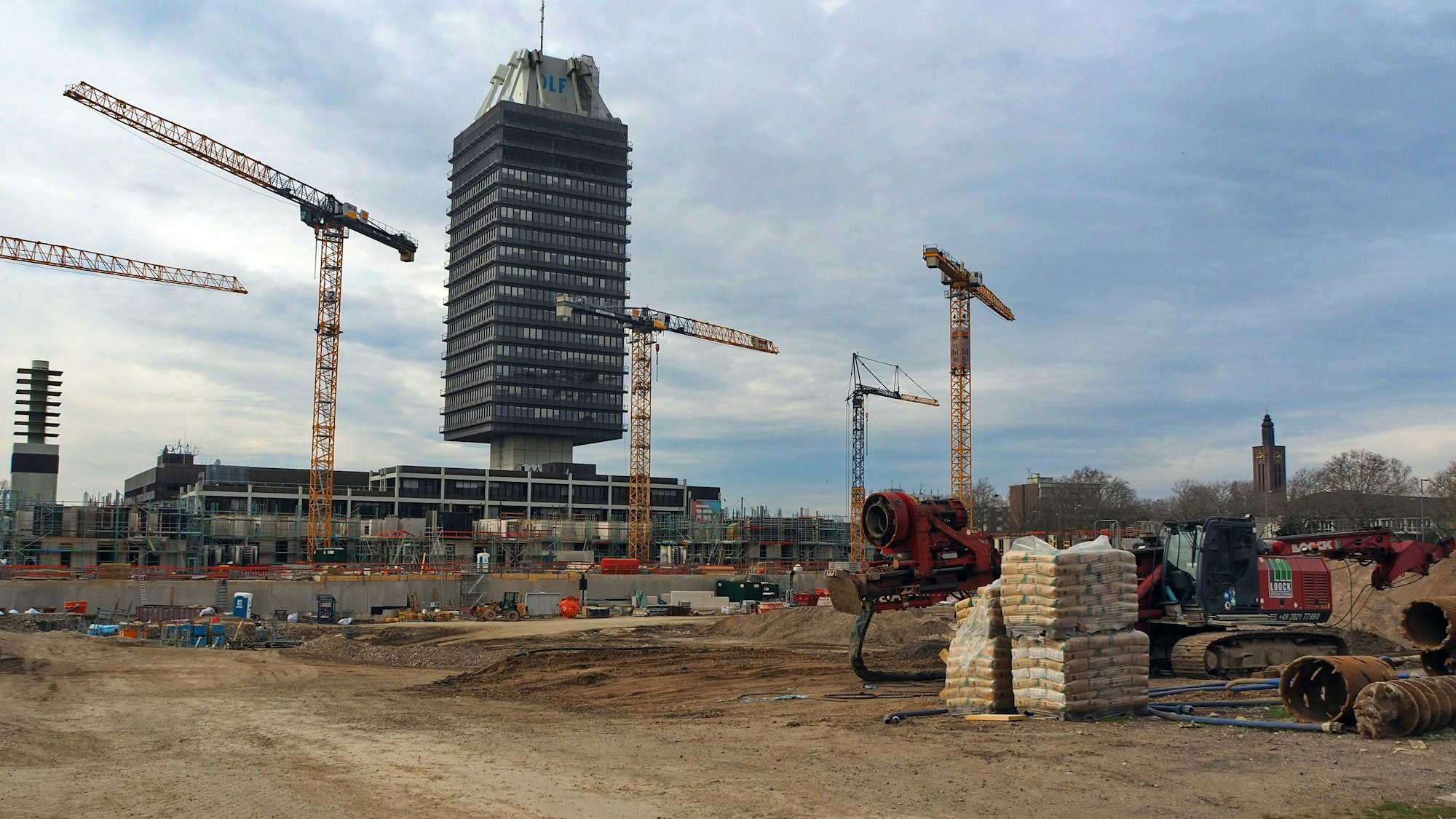 Blick auf eine riesige Baustelle mit vielen Kränen und ein Hochhaus