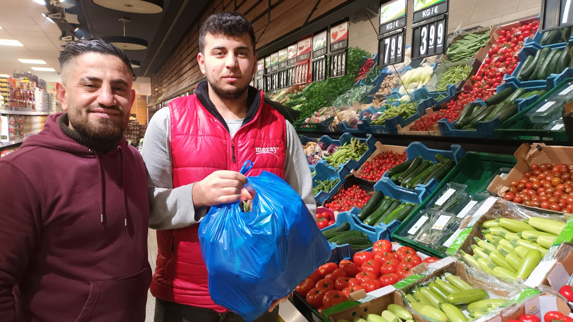 Zwei Männer an einem Gemüsereal im Supermarkt