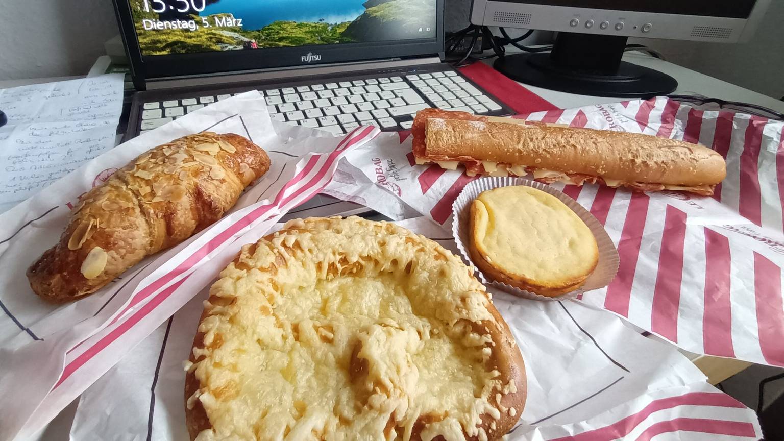 Backwaren liegen vor einem aufgeklappten Laptop
