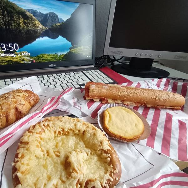 Backwaren liegen vor einem aufgeklappten Laptop