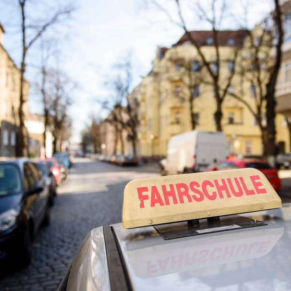 Ein Schild mit der Aufschrift «Fahrschule» ist auf dem Dach eines Fahrschulwagens montiert.