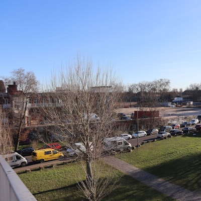 Blick auf eine Rasenfläche und angrenzendes Fabrik-Areal