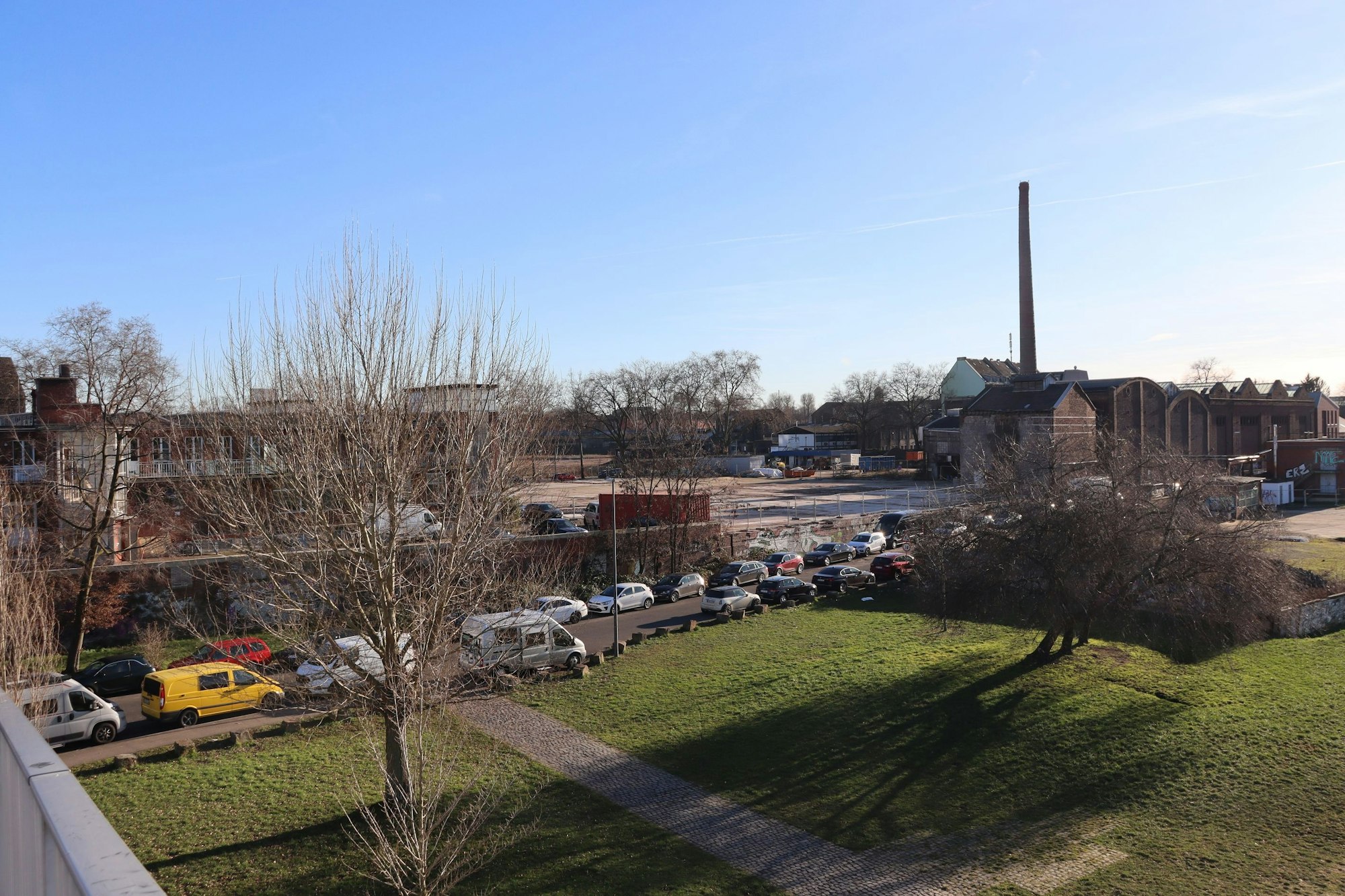 Blick auf eine Rasenfläche und angrenzendes Fabrik-Areal