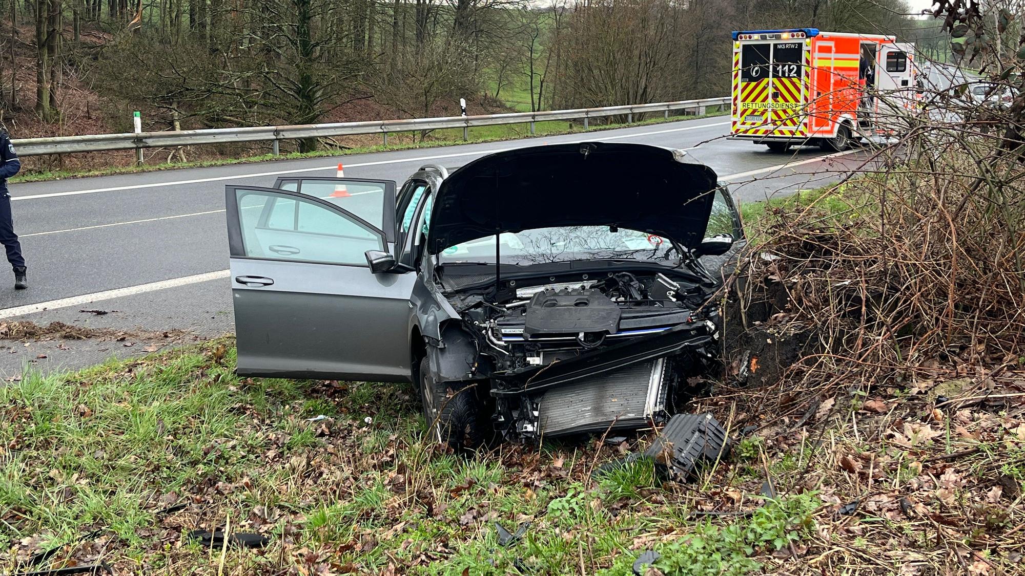 Ein zerstörtes Auto steht neben einer Straße.