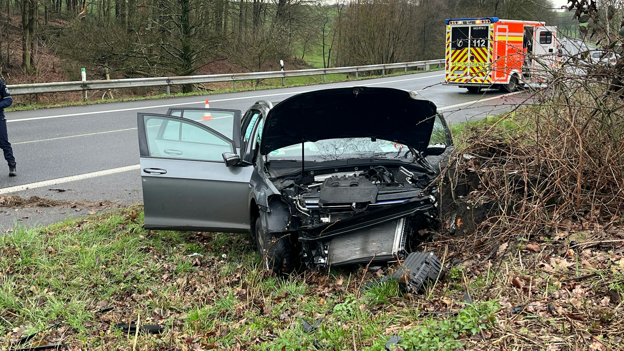 Ein zerstörtes Auto steht neben einer Straße.