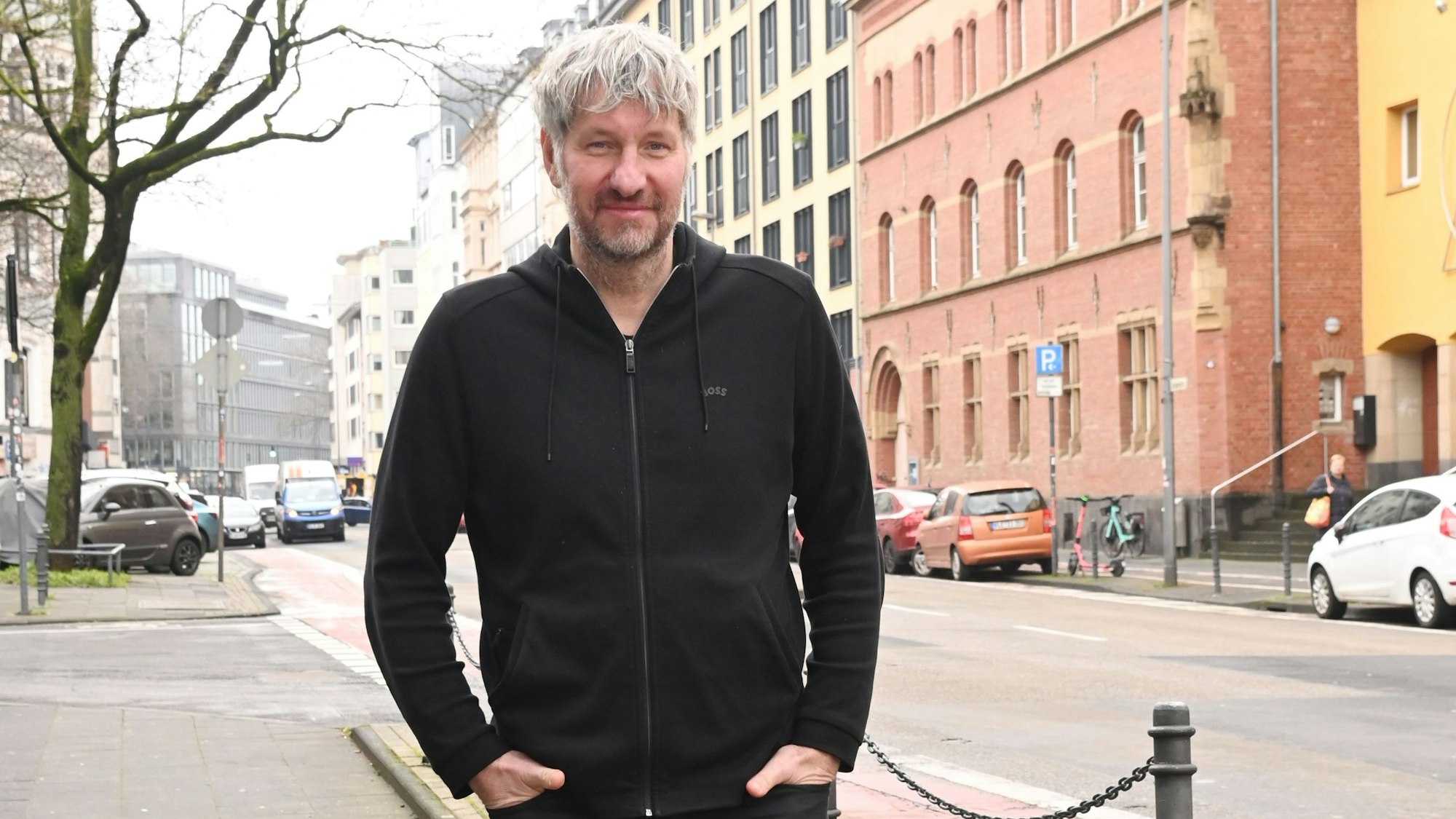 Wiebusch in schwarzer Jacke auf einer Kölner Straße.