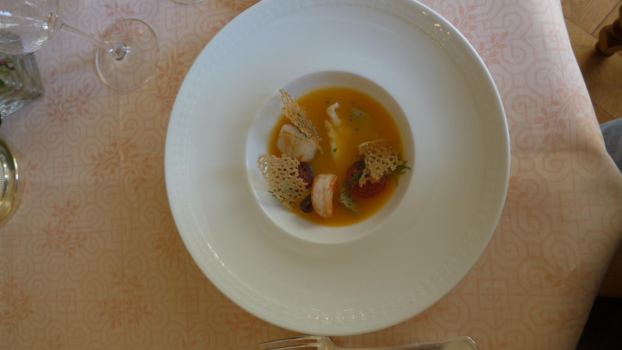 Zu sehen ist ein runder tiefer Teller mit einer Suppe.