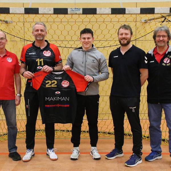Trainer Peter Trimborn und Marius Schmitz halten das Trikot mit der Nr. 22 hoch. Daneben stehen die beiden Vorsitzenden und René Lönenbach.