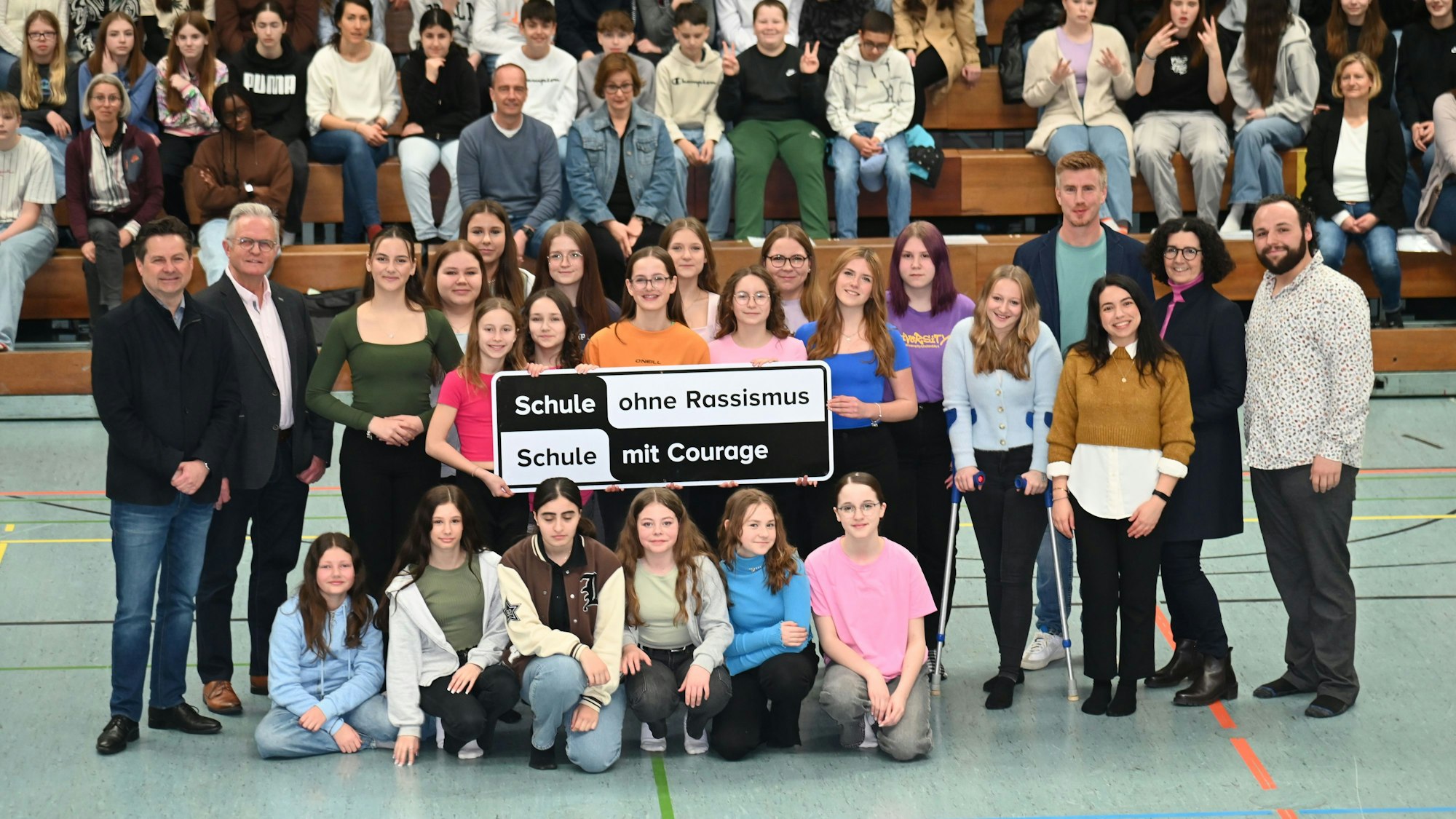 Schüler zeigen das Schild „Schule ohne Rassismus“.