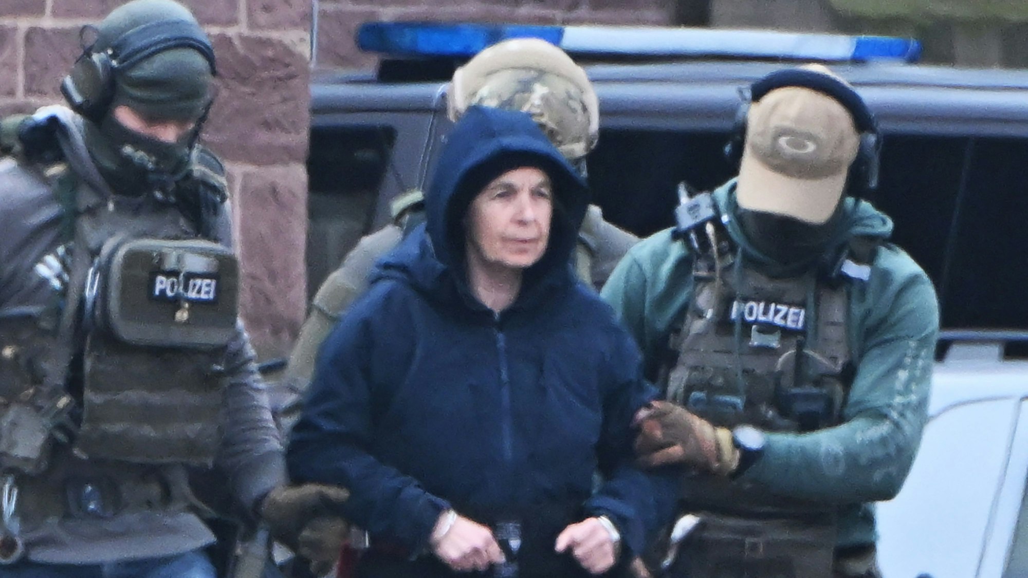 Die frühere RAF-Terroristin Daniela Klette wird von Polizeibeamten nach ihrer spektakulären Festnahme abgeführt.