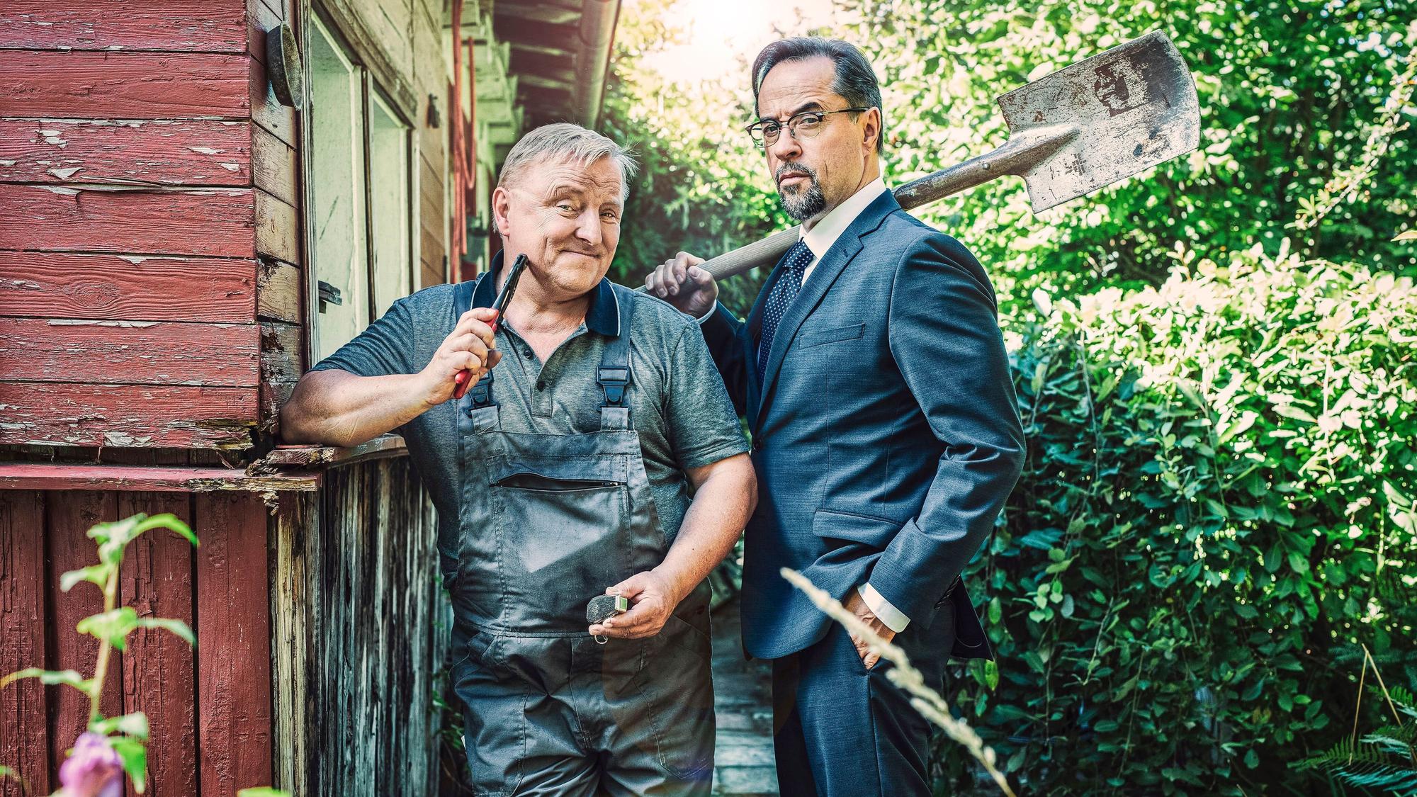 Thiel (Axel Prahl) und Professor Boerne (Jan Josef Liefers, r) verschlägt es in den Schrebergarten.