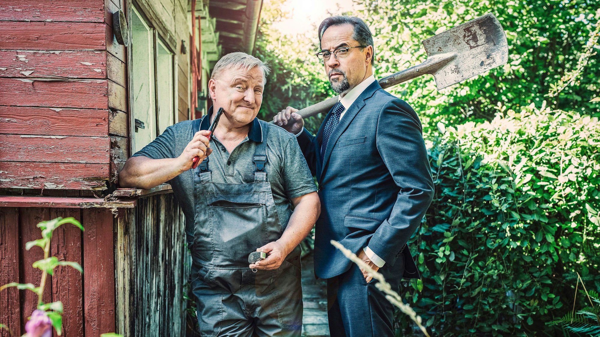 Thiel (Axel Prahl) und Professor Boerne (Jan Josef Liefers, r) verschlägt es in den Schrebergarten.