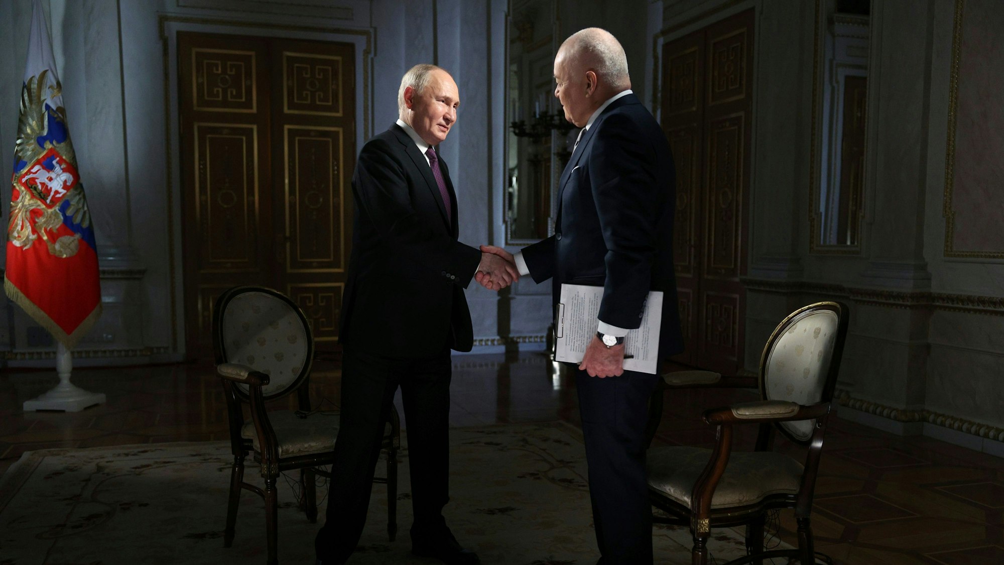 Wladimir Putin begrüßt Dmitri Kisseljow. Der Propagandist ist Chef der Mediengruppe „Rossiya Segodnya“ und hat kürzlich mit Spekulationen über Angriffe auf Brücken in Deutschland für Wirbel gesorgt.