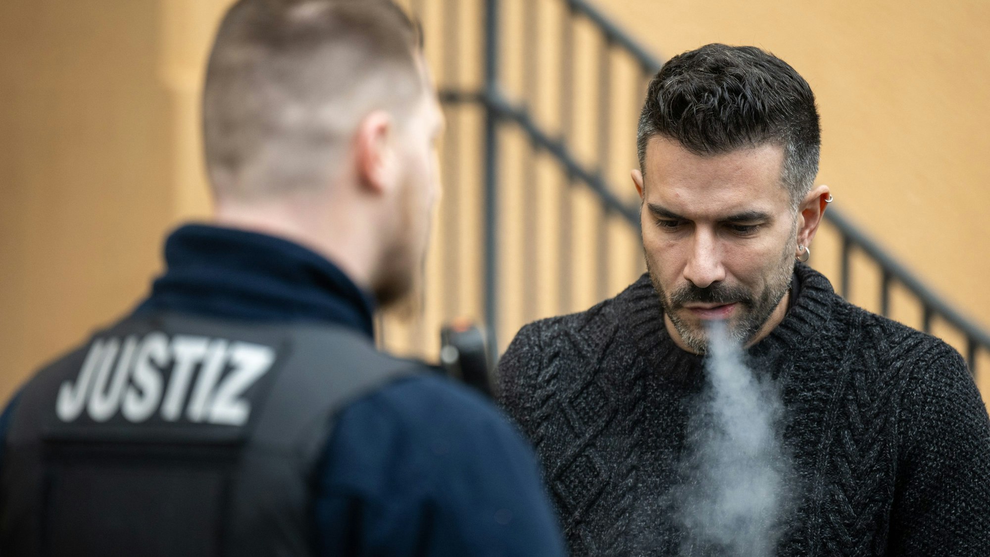 Marc Terenzi raucht neben einem Justizbeamten auf dem Hof des Amtsgerichts Borna.