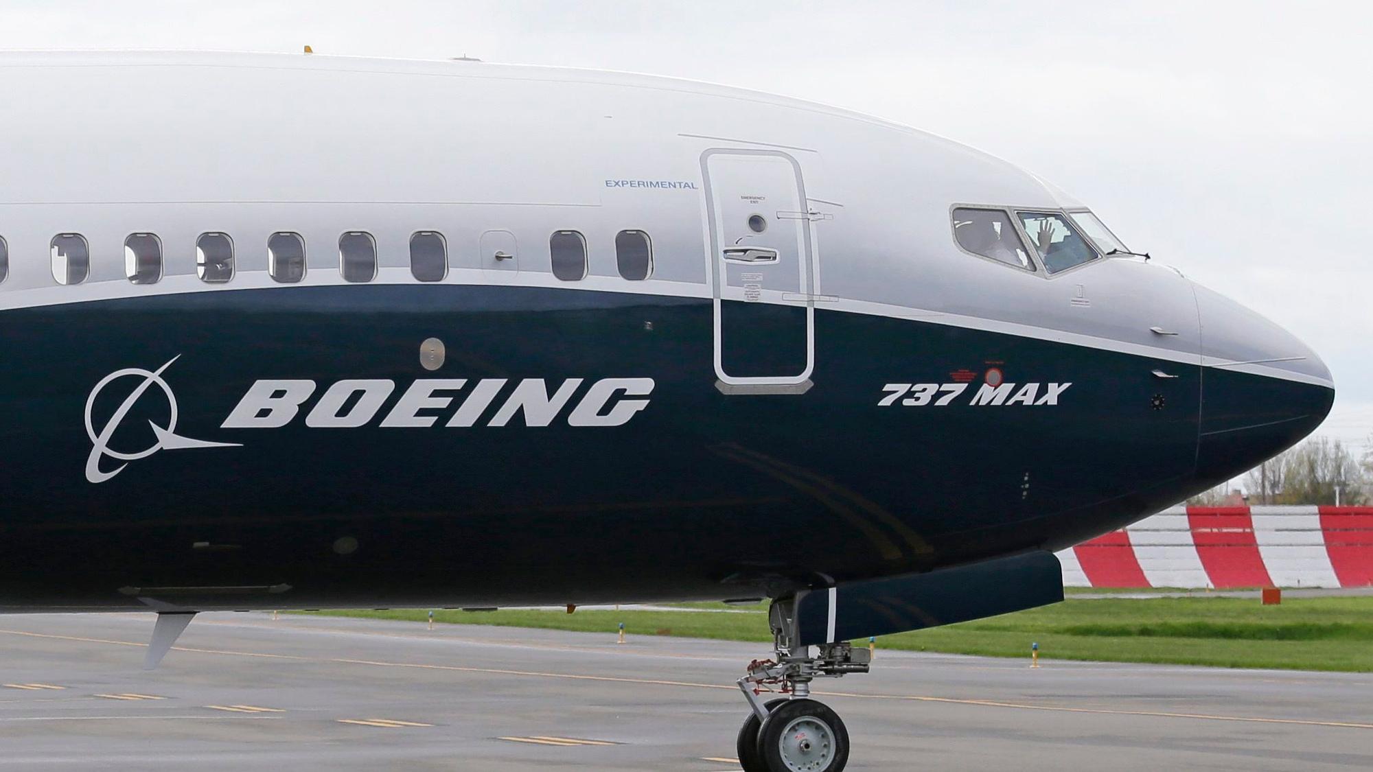 Ein Pilot winkt aus der Pilotenkabine eines Flugzeuges vom Typ Boeing 737 MAX 9 auf dem Flughafen.