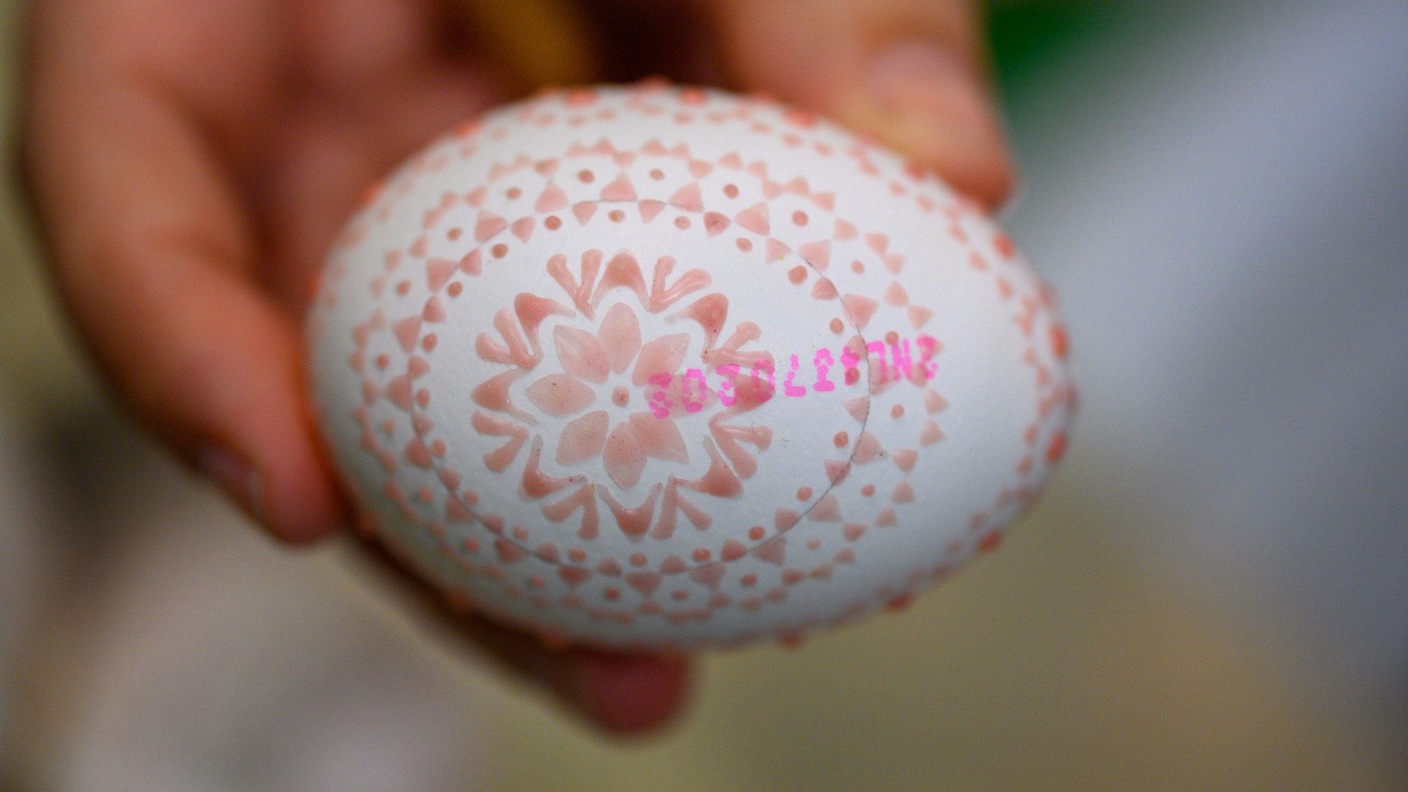 Der Prüfstempel des Hühnereis ist noch unter dem Wachsmuster zu sehen.