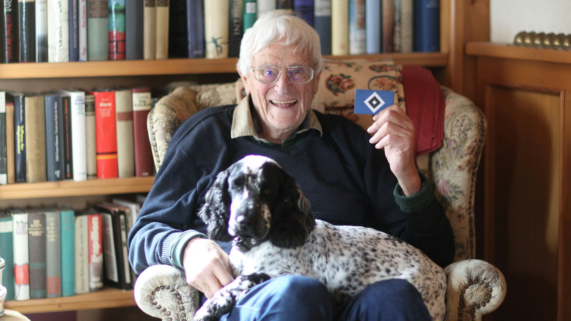 Radio-Moderator-Legende Dietmar Schott (86) präsentiert stolz seine Mitgliedskarte und hat seinen Hund Friso auf dem Schoss sitzen.