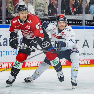 Zwei Eishockey-Spieler stehen dicht gedrängt auf der Spielfläche.
