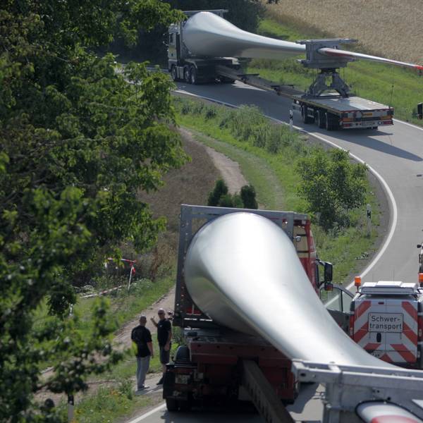 Ein Konvoi von Transportern mit Windradflügeln steckt am 10.07.2014 auf der Straße von Wöllstein nach Neu-Bamberg (beides Rheinland-Pfalz) fest. Der erste von sechs Großtransportern mit Windradflügeln ist in einer Kurve in Rheinhessen steckengeblieben. So war die Kolonne vor dem Ort Neu-Bamberg unfreiwillig zu einer Pause gezwungen worden. Foto: Fredrik von Erichsen/dpa ++ +++ dpa-Bildfunk +++