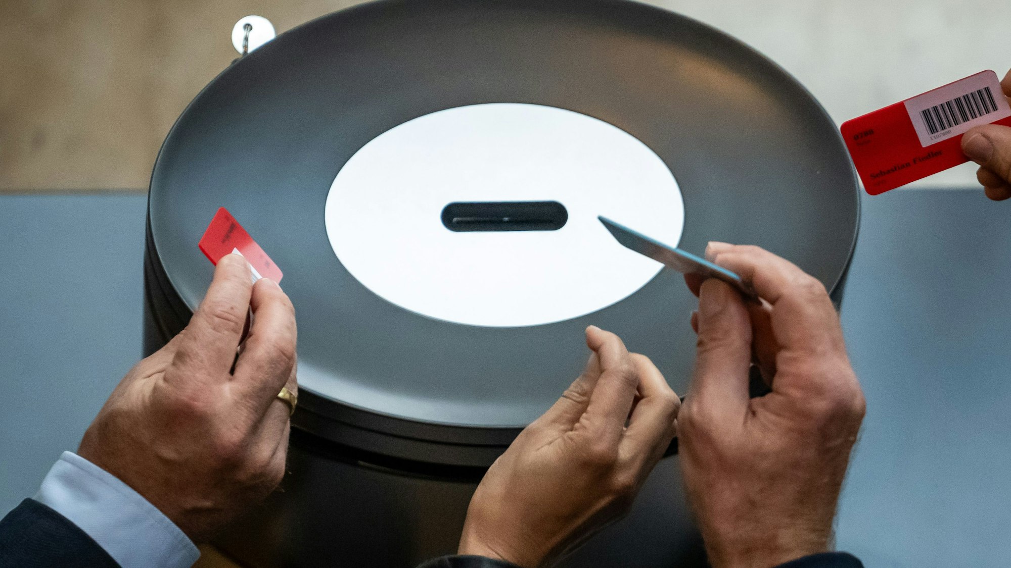 Abgeordnete werfen im Bundestag ihre Stimmkarte in der namentlichen Abstimmung ein.