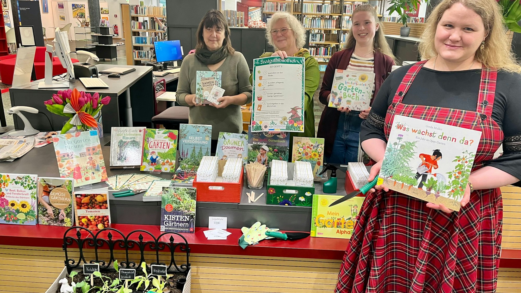 Vier Frauen mit Saatgut und Garten-Büchern