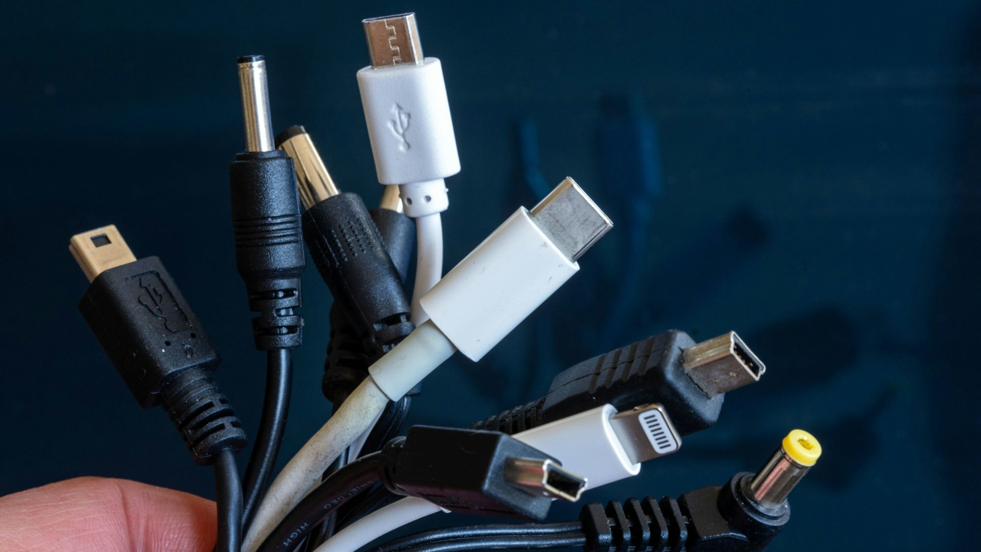 Ein Bündel unterschiedlicher Ladekabel für Elektrogeräte wie Mobiltelefone oder Laptops.