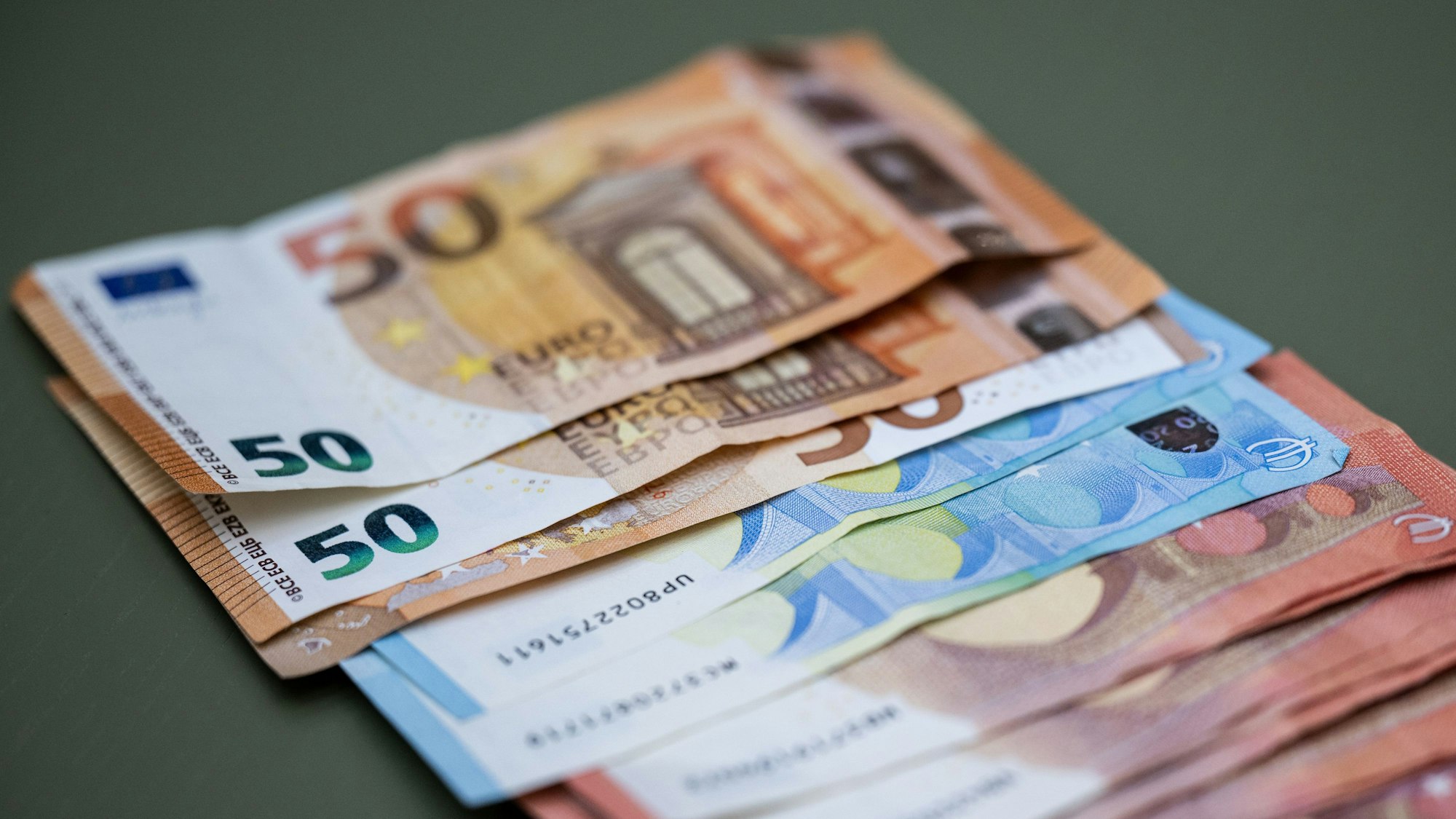 Zahlreiche Euro-Banknoten liegen auf einem Tisch.